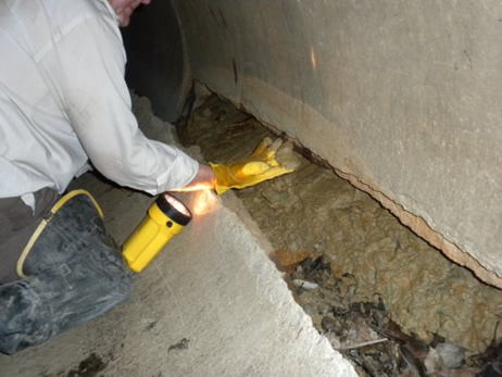 A longitudinal split in a concrete pipe